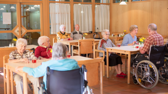 Elderly people sit in a dining room at a nursing home