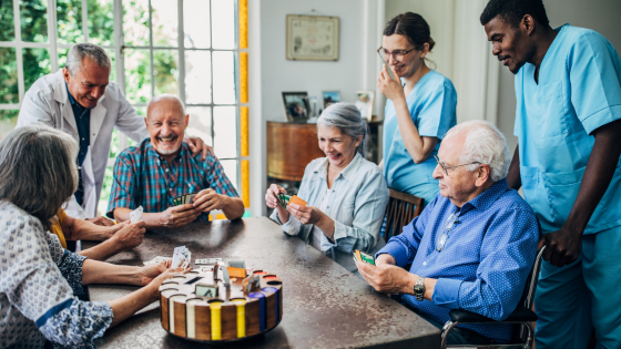 A group of elderly patients and nurses gather around a table at a nursing home in Columbia, MO, a scene while touring a nursing home